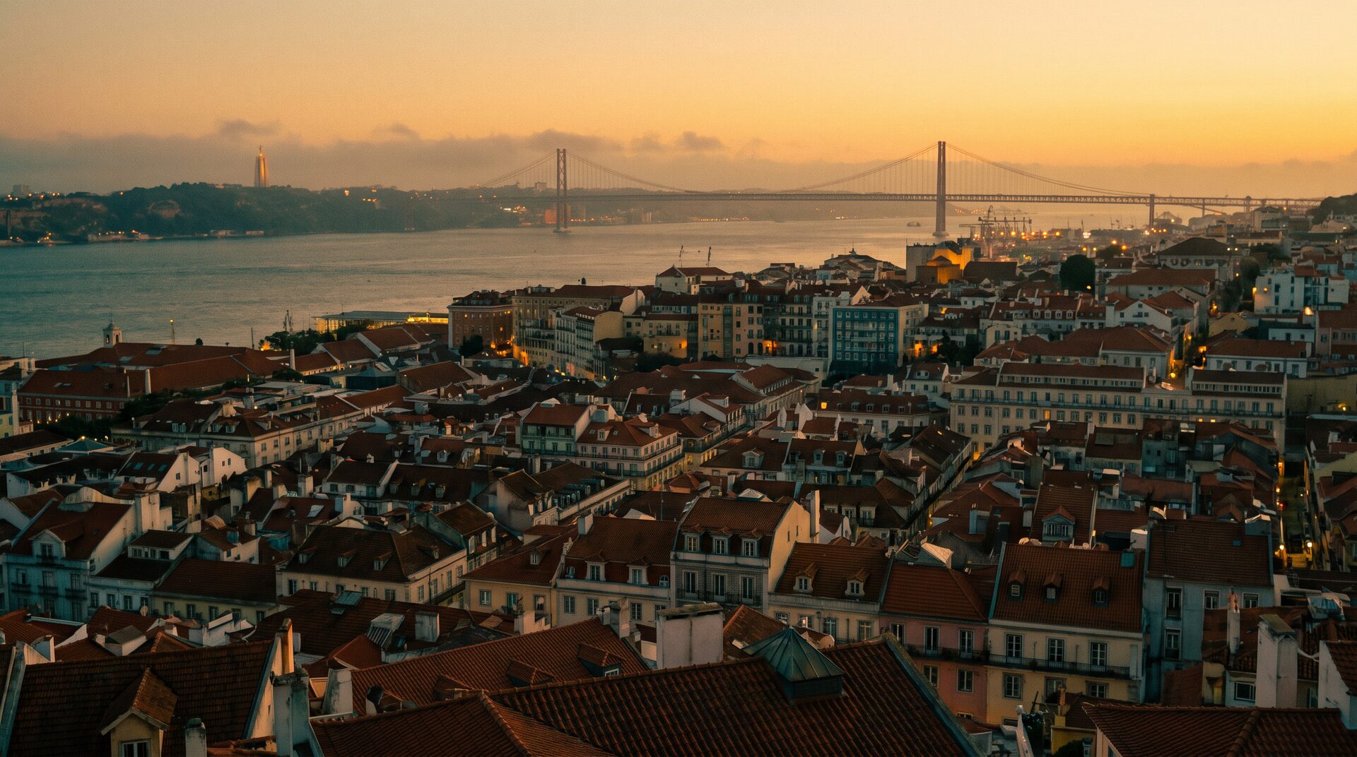 Aerial view of Lisbon rooftops and the Tejo river at golden hour